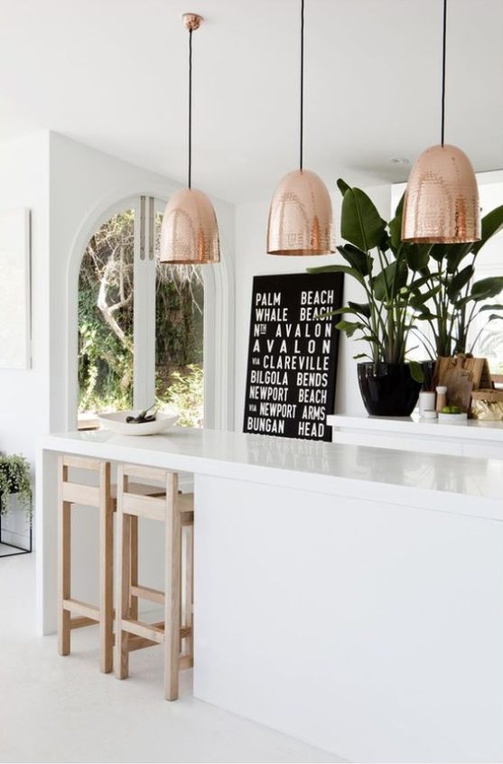 White kitchen unit with 3 big copper ceiling lights