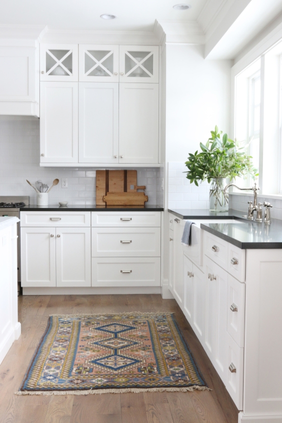 A small colourful rug in a white kitchen