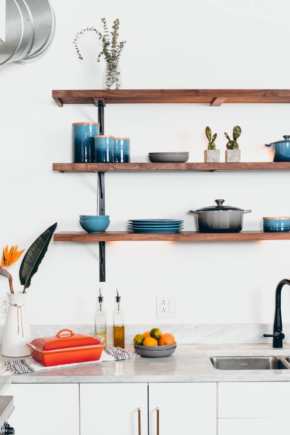 Blue dining plates displayed on shelves in a white kitchen