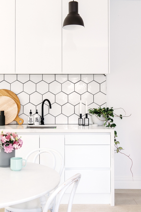 White kitchen unit with white hexagon tiles with black tile grout