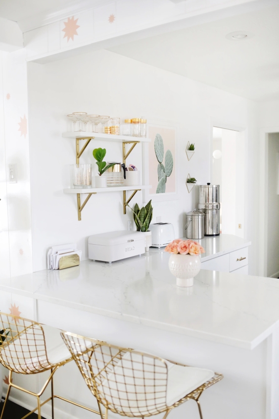 White kitchen with golden metal stools