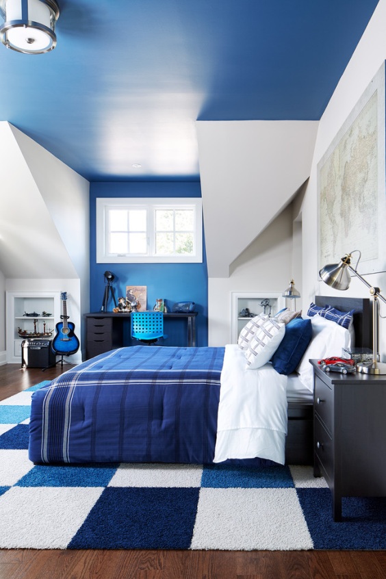 boy bedroom with dark blue ceiling and blue and white rug and white walls
