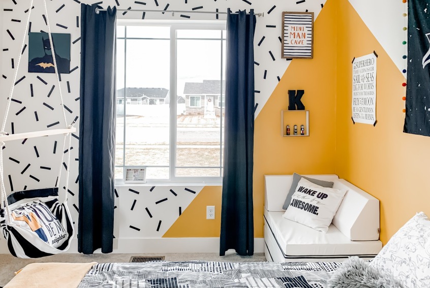 colourful child’s bedroom with geometric paint effect in yellow, dark blue and white colour scheme with and dark blue curtains