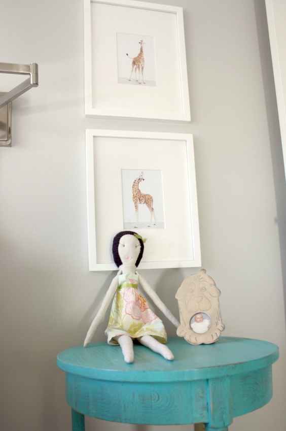 girl’s bedroom with detail of a painted light blue wooden stool and two white pictures in white frames on the wall